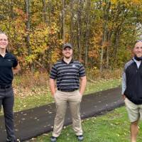 Three alumni by golf course